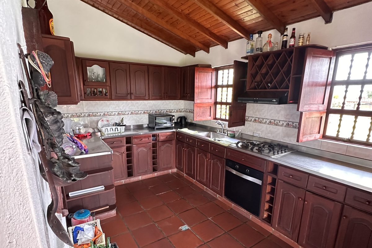 Cocina completa de La Amalita en madera, con estufa de gas, horno, mesón largo y techo de madera