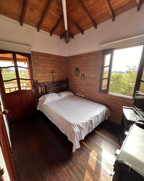 Habitación con dos camas sencillas y puerta que sale al corredor techado